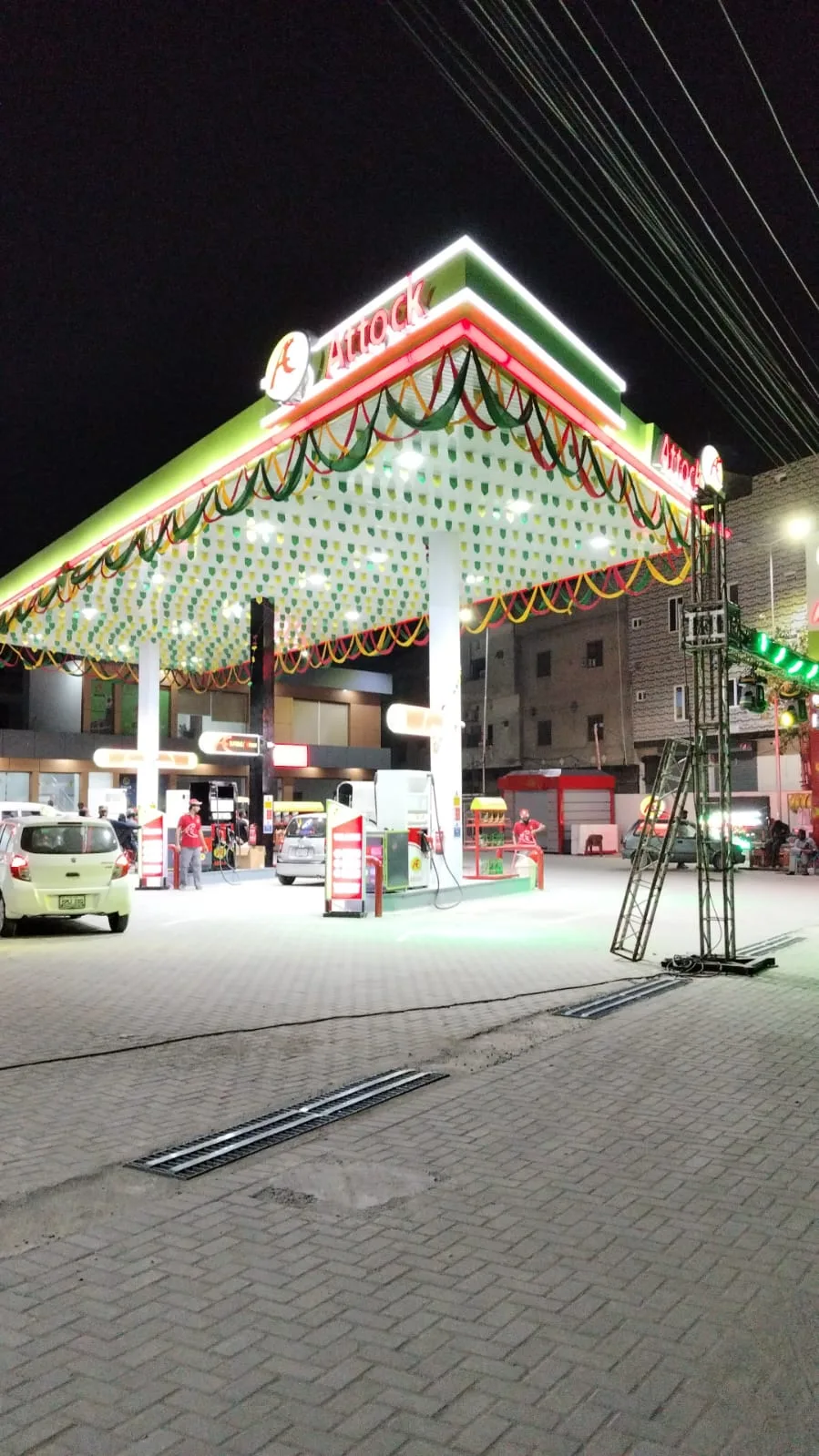 Night view beneath the illuminated Attock Petroleum Wahdat Road canopy